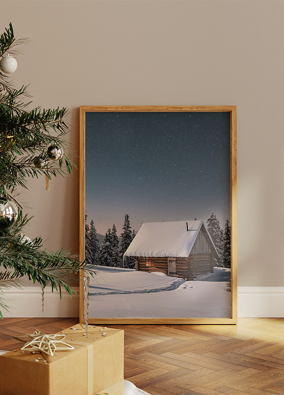 a picture of a snowy cabin with a christmas tree in the foreground