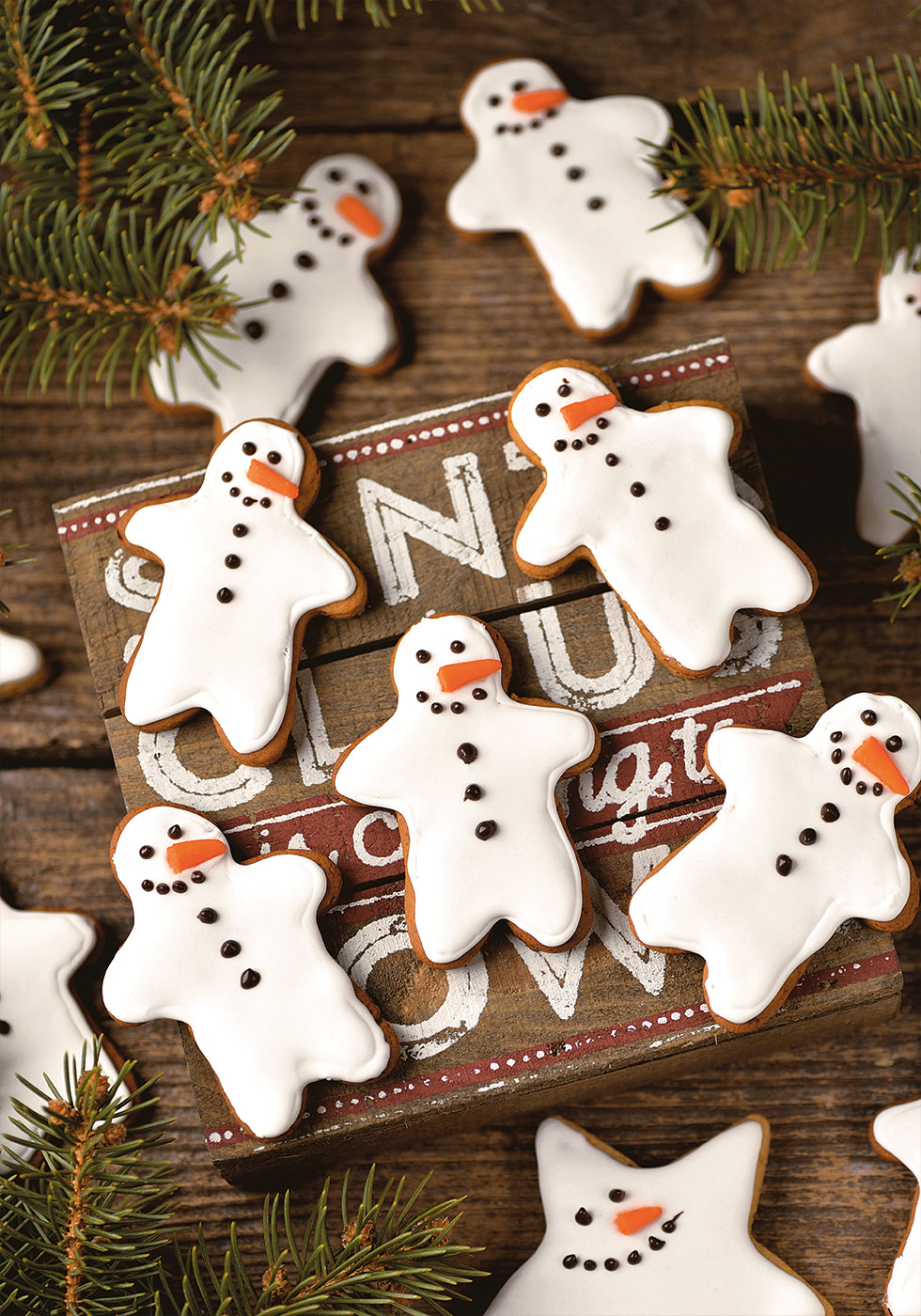 a wooden table topped with lots of decorated cookies