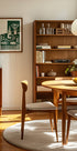 a cozy and well-organized dining room with a wooden table, chairs, and a bookshelf filled with books and decorative items.